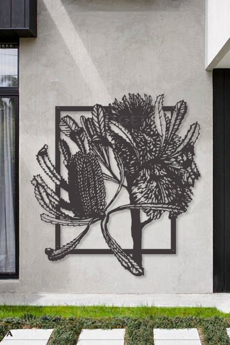 Banksia Wall Art  This piece features a laser-cut metal silhouette of banksia, finished with a black powder coating. It is displayed against a modern concrete wall, creating a dramatic contrast with its sleek, minimalist design. The banksia's intricate details stand out vividly against the textured backdrop.